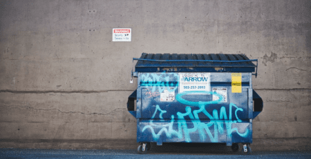 A dumpster against a wall.
