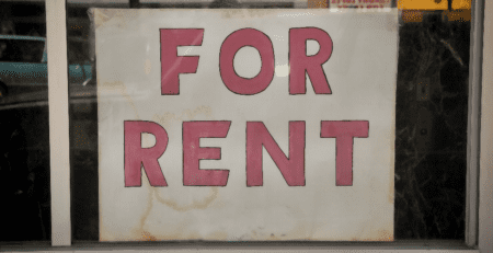 A window displaying a "for rent" sign.