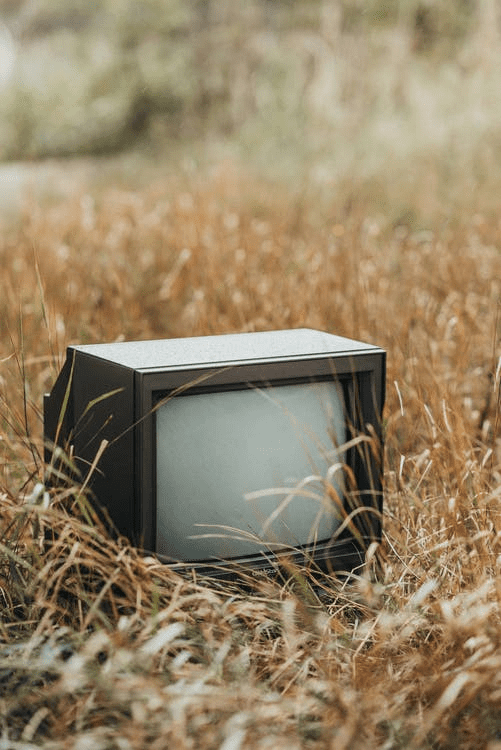 An old TV, leading to e-waste on the grass