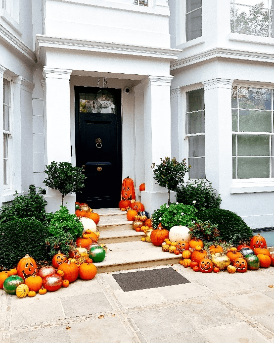 A house entrance decorated with pumpkins.