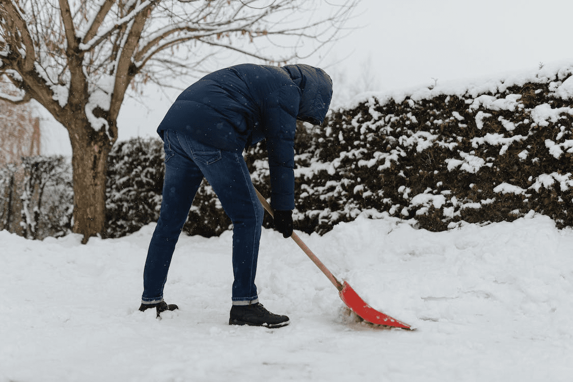 A person cleaning their yard during the winter