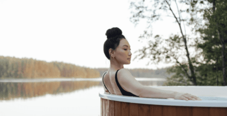 A woman is sitting in a wooden hot tub
